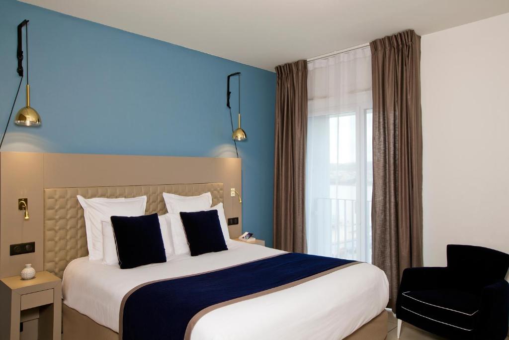波尔多波尔多住家酒店的酒店客房带一张大床和一把椅子