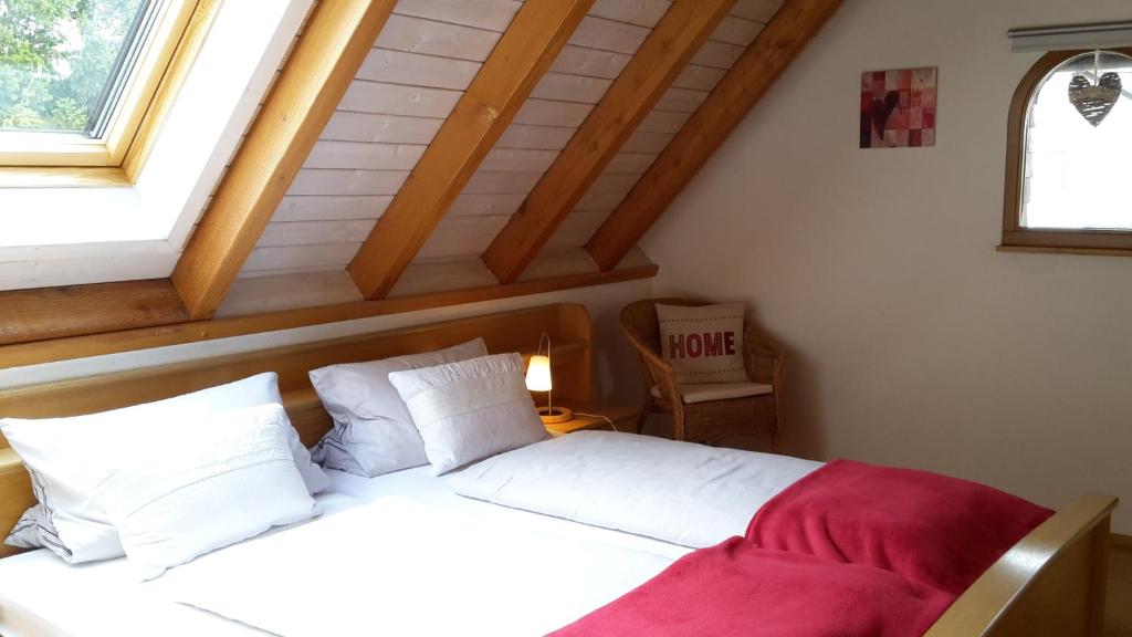 勒芬根Ferienwohnung Hasenfratz的一间卧室配有一张带白色床单的床和一扇窗户。