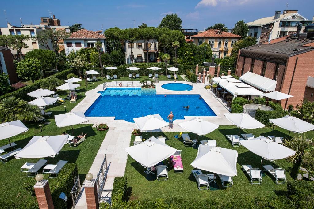 威尼斯丽都DB Villas Le Ville del Lido Resort的享有带白色遮阳伞的游泳池的顶部景致