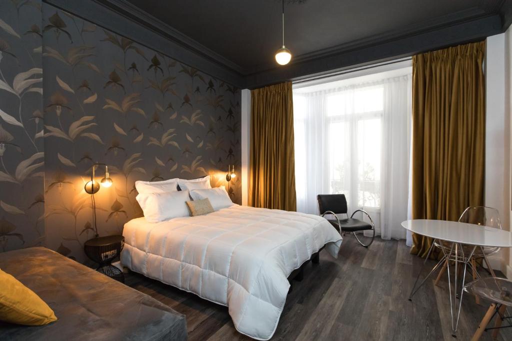 尼斯阿罗米酒店的酒店客房配有一张床铺和一张桌子。