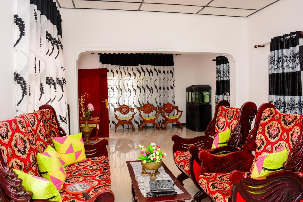 尼甘布Gloriya Mathews的客厅配有红色椅子和桌子