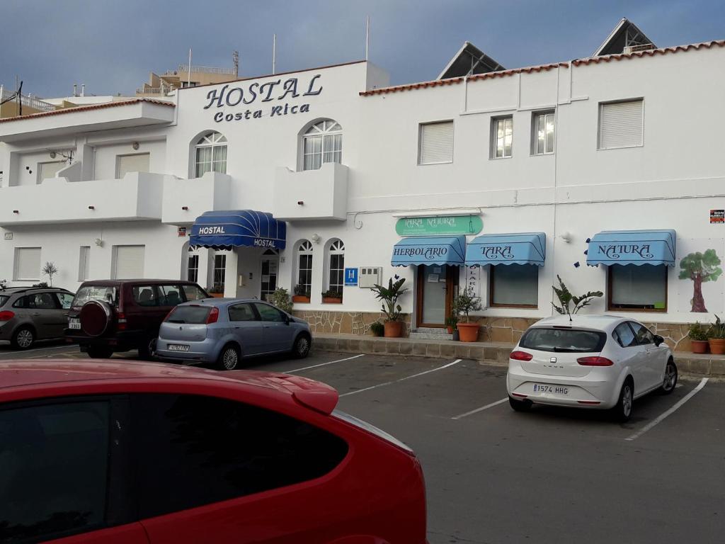 圣何塞哥斯达黎加旅馆的一座白色的大建筑,汽车停在停车场