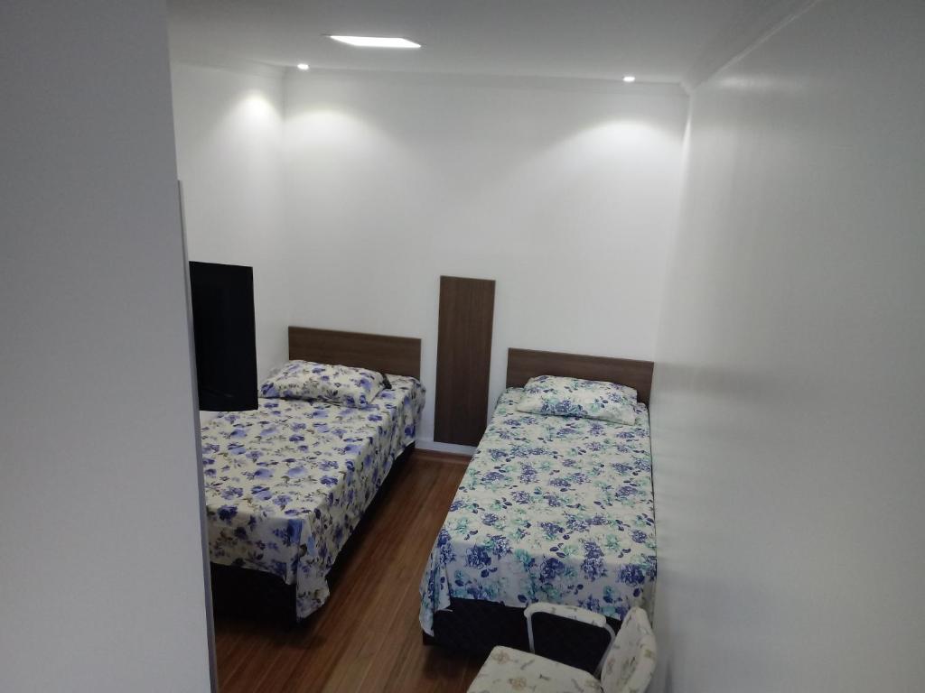 南圣克鲁斯Mini Kitnet - Santa Cruz do Sul的客房设有两张床和一台墙上的电视。