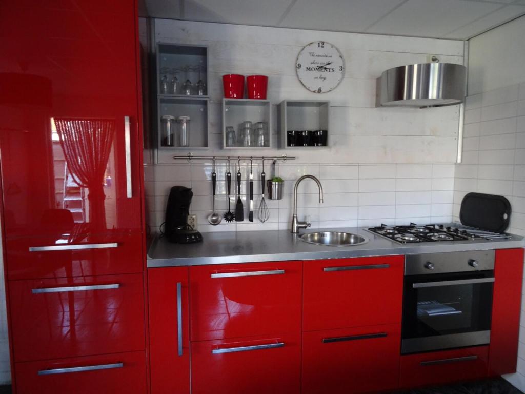 雷讷瑟Het Pronkje的红色的厨房设有水槽和炉灶