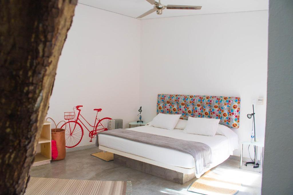 瓦哈卡市Hotel Cosijo - San Jeronimo Tlacochahuaya的一间卧室配有一张床和一辆红色自行车