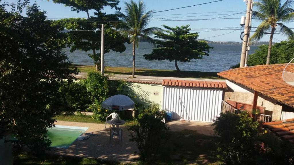 萨夸雷马Recanto do Surf的享有带遮阳伞和游泳池的房屋景致