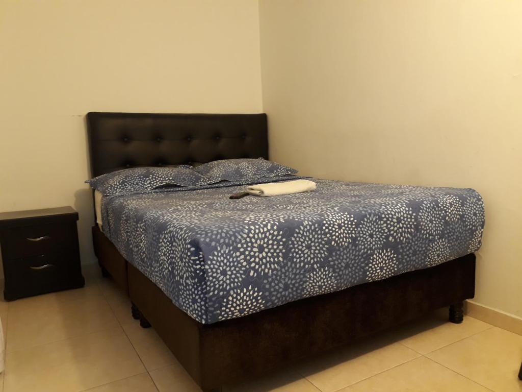波哥大Aparta Hotel Victoria In的一间卧室配有一张带蓝色棉被的床
