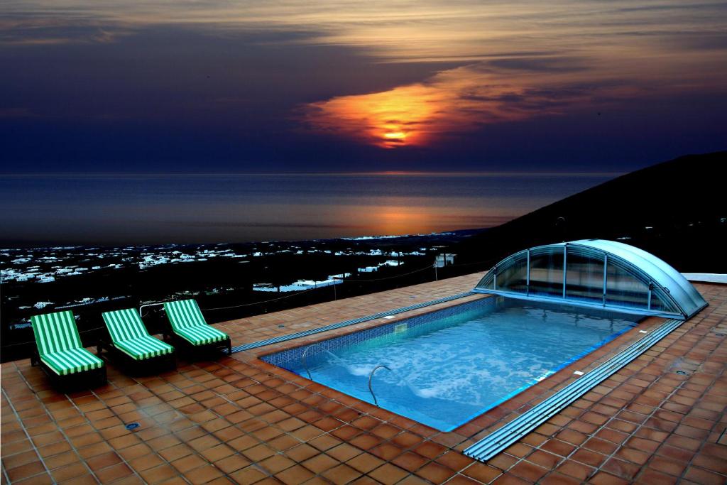 阿索马达Casa Tinasoria的一座带椅子的建筑屋顶上的游泳池