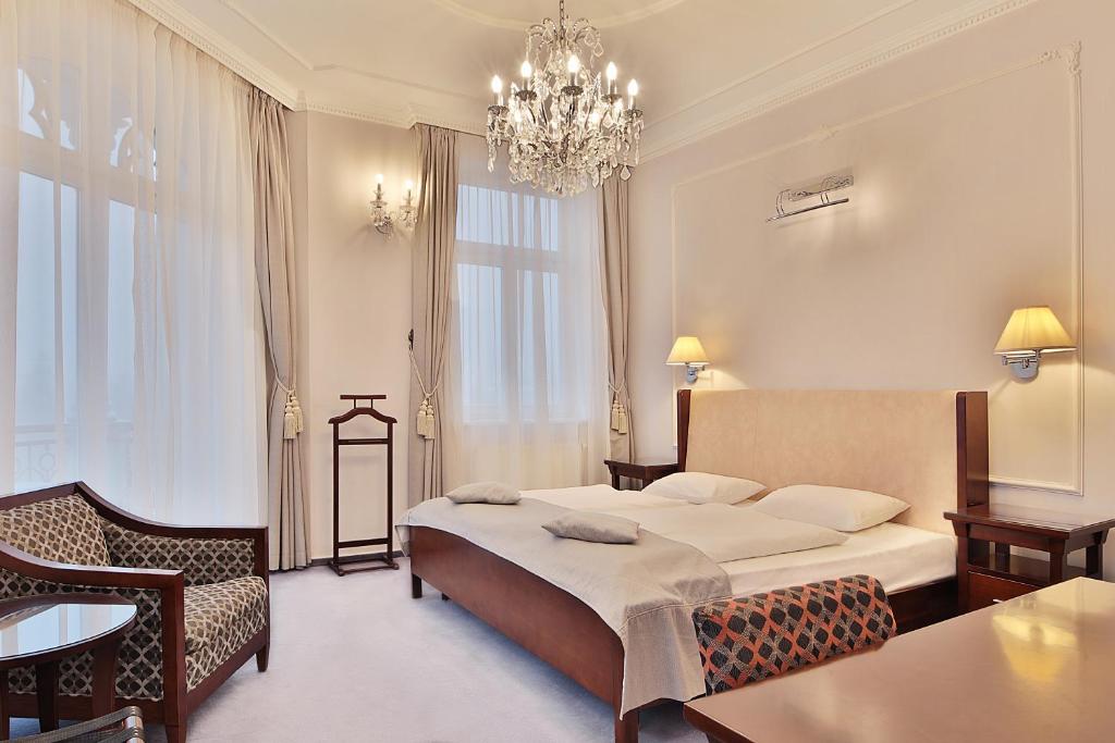 玛丽亚温泉Sun Palace Wellness Hotel的酒店客房,配有一张床和吊灯