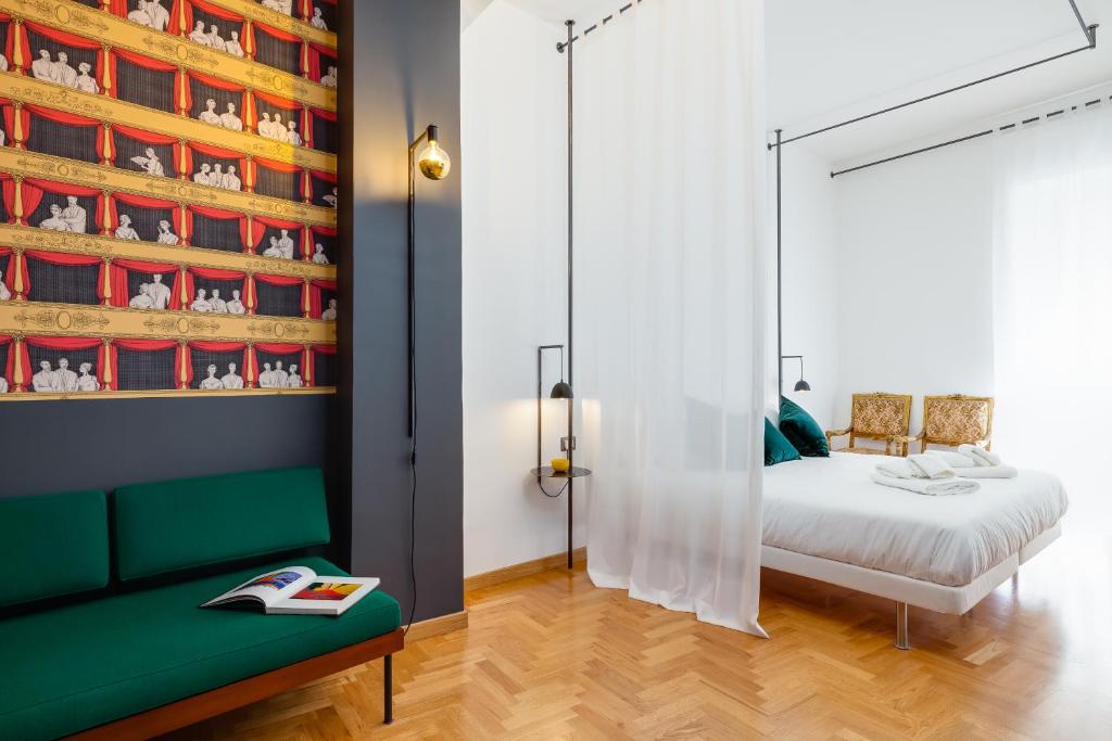 那不勒斯ALMA de Toledo Design Home Plebiscito的一间卧室配有一张床和一张绿色沙发
