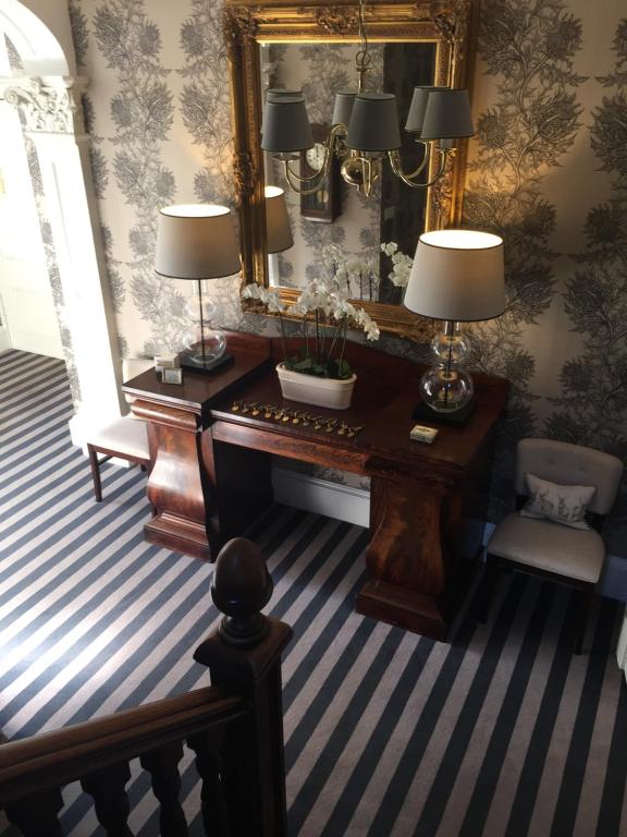 奥本Glenburnie House的一间设有钢琴和镜子的客房