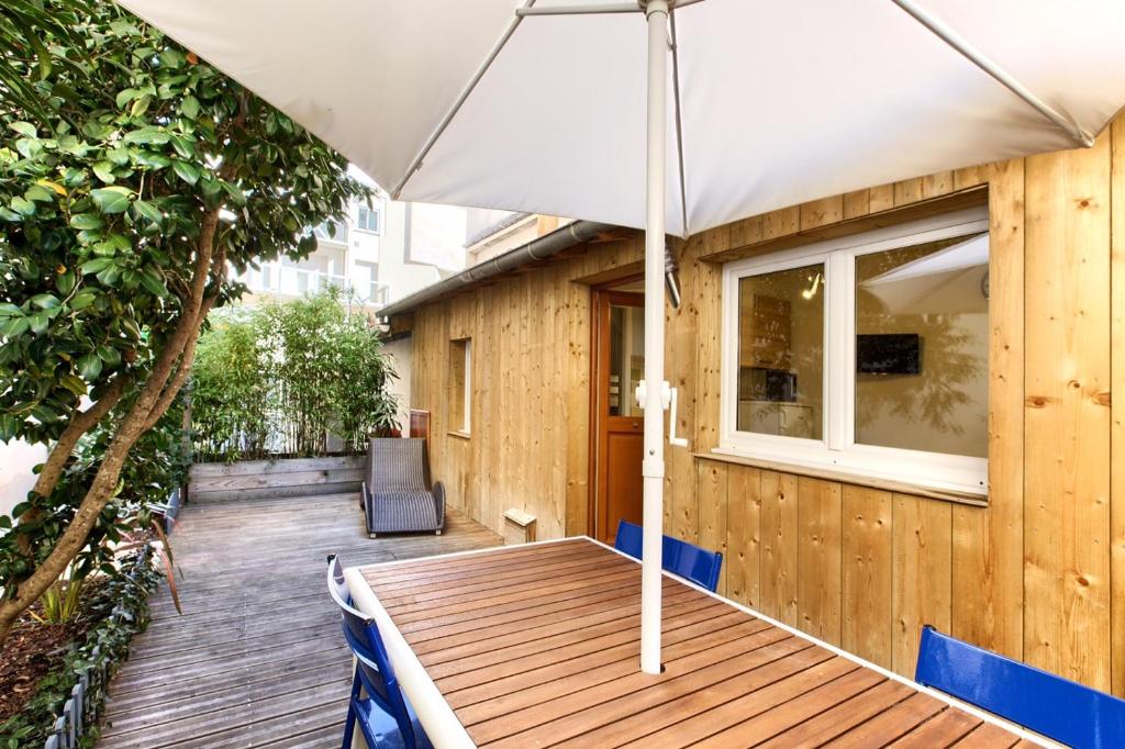 阿卡雄Location avec terrasse的房屋内带遮阳伞的木制甲板