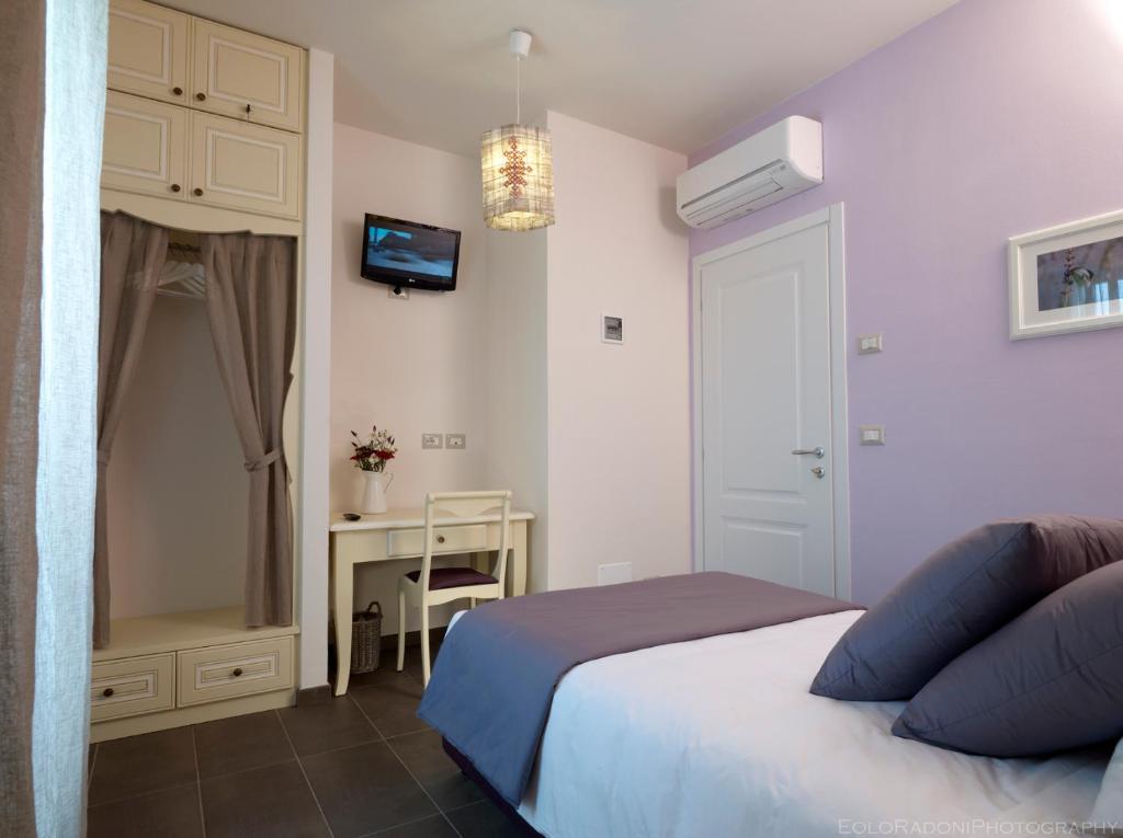 福林波波利洛坎达阿拉马诺旅馆的一间卧室配有一张床和一张桌子及一台电视
