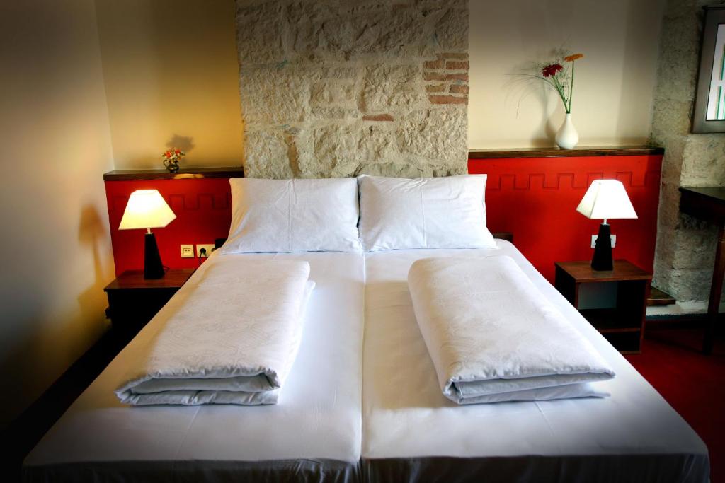 比奥格勒·纳·莫鲁卡尔皮摩尔酒店的卧室配有一张带白色床单和枕头的大床。