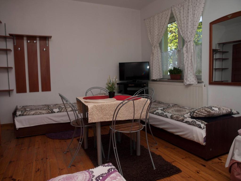 拉辛Pokoje Gościnne "Amelia"的一间设有两张床和一张桌子及椅子的房间