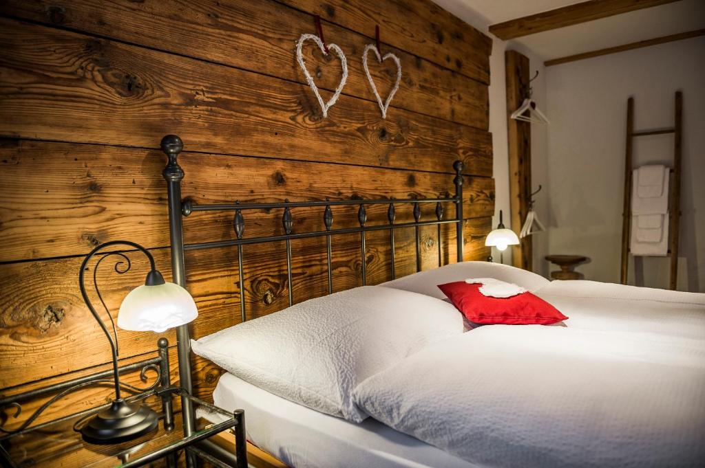 格施泰格维勒B3 Boutique-Bed&Breakfast的卧室配有白色的床和木墙