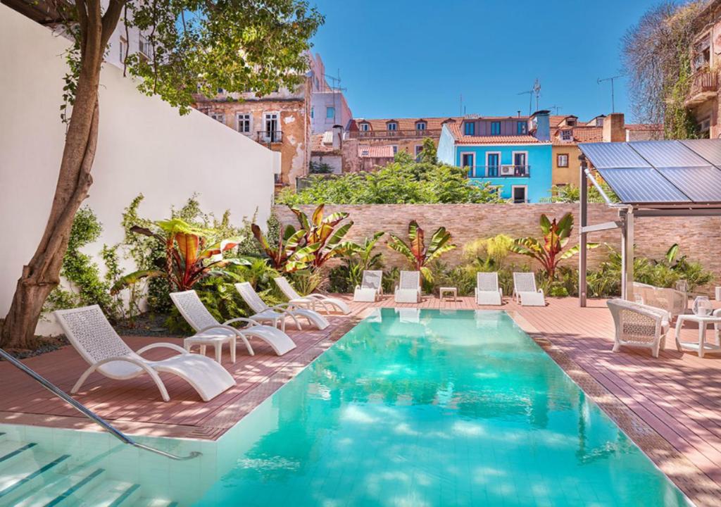 里斯本Hapimag Apartments Lisbon的一个带白色椅子的游泳池以及一座房子