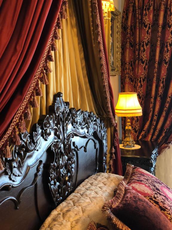 维尔纽斯Grand Duke Apartments的一间卧室配有一张带红色窗帘和灯的床
