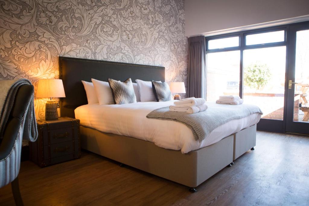 RuabonWynnstay Arms, Ruabon, Wrexham的一间卧室配有一张大床和两条毛巾
