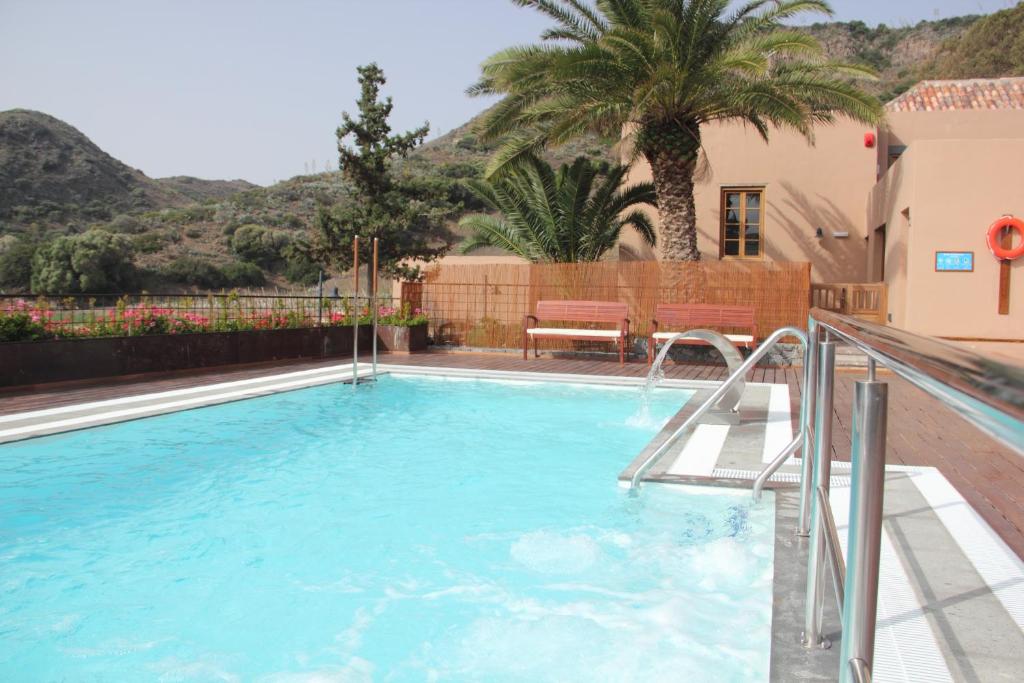 大加那利岛拉斯帕尔马斯艾尔蒙达隆乡村酒店的棕榈树房子中的游泳池