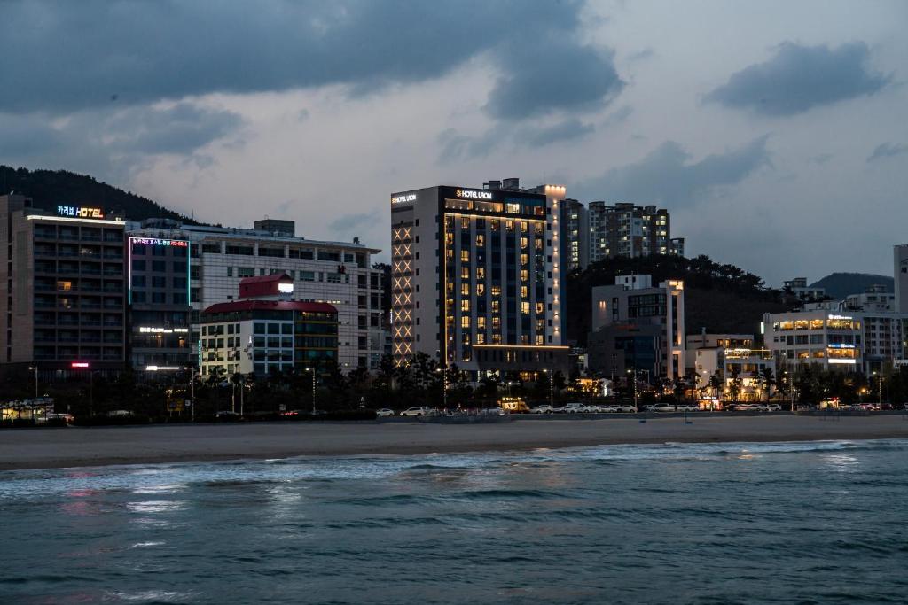 釜山拉昂酒店的一座城市,晚上有海滩和建筑