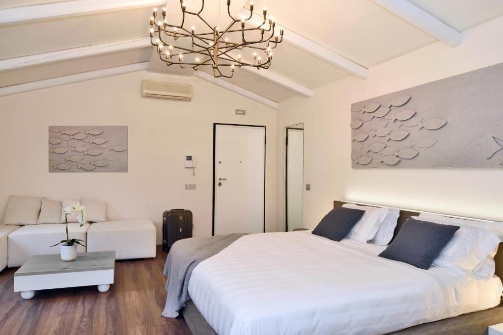 里奥马哲雷Terra Prime Suite的卧室配有一张白色大床和吊灯。