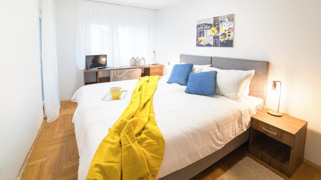 贝尔格莱德诺韦尔公寓的一间卧室配有一张大床,床上有黄色的毯子