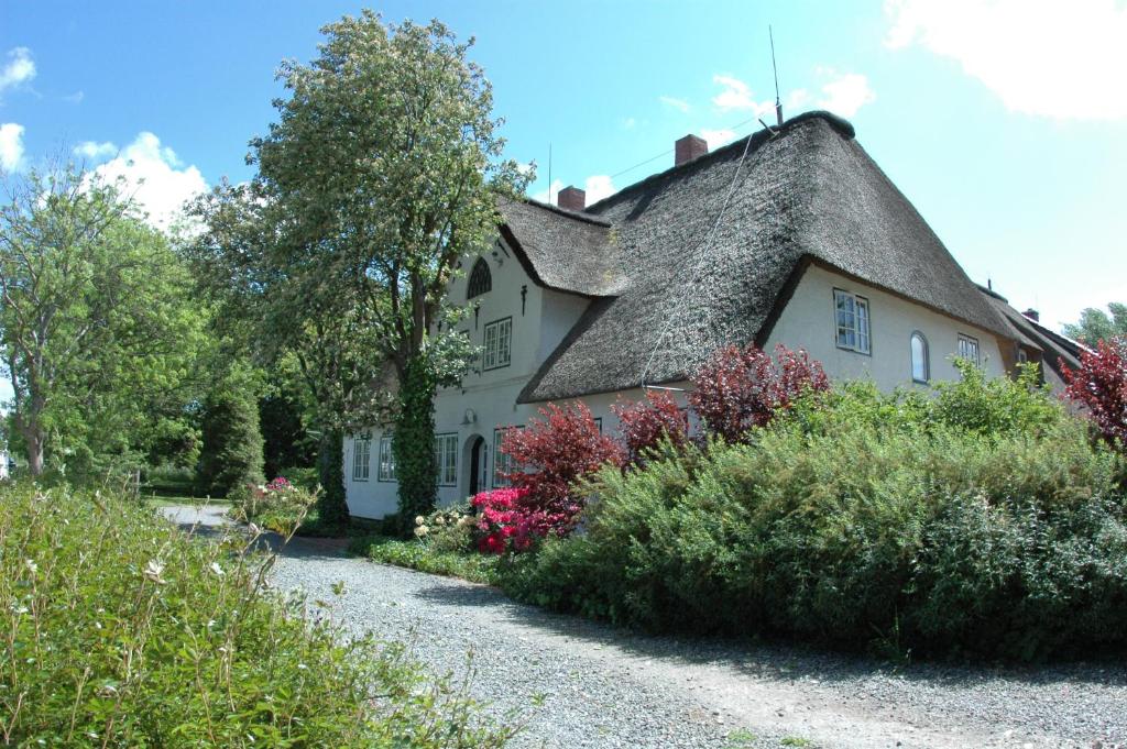 塔廷格Hof Luisengrund的一座带茅草屋顶的大型白色房屋