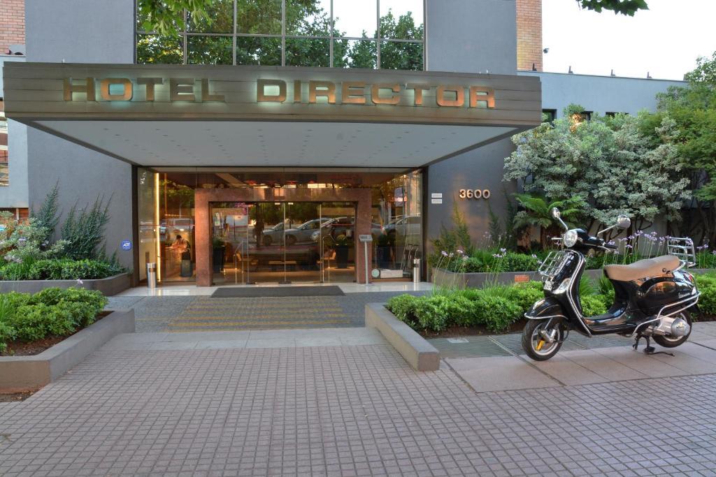 圣地亚哥维塔库拉董事酒店的停在大楼前的摩托车