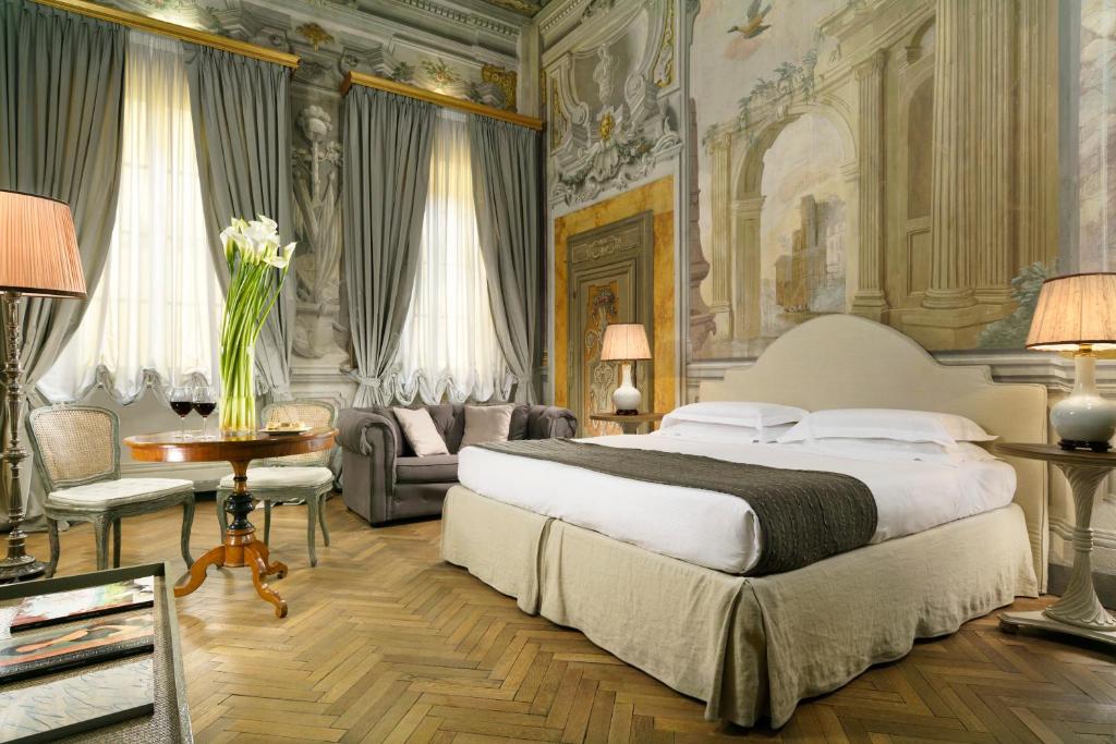 佛罗伦萨加木格里诺侯爵宫依波娜酒店的一间卧室配有一张床、一张沙发和一张桌子