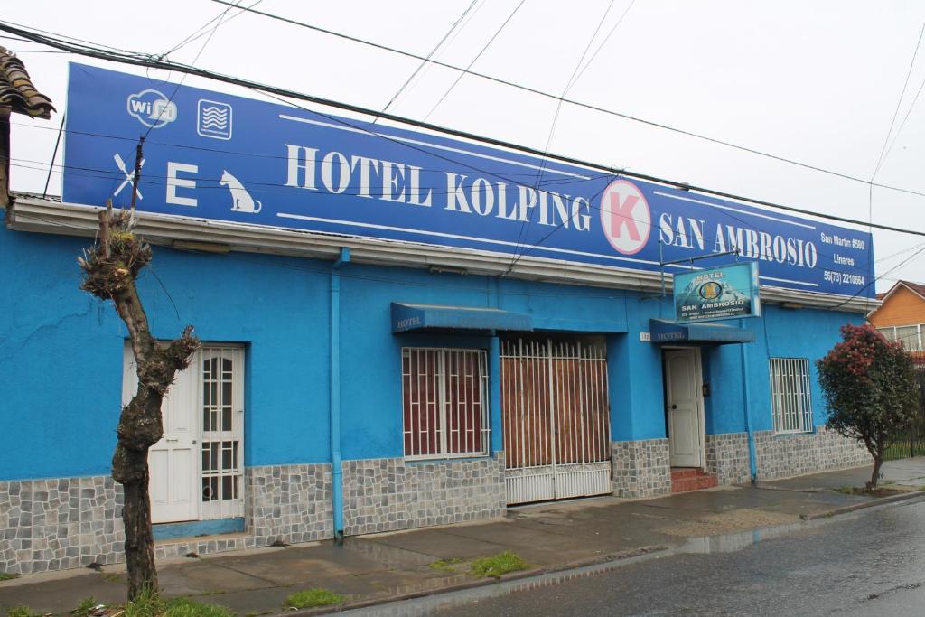 利纳雷斯Hotel Kolping San Ambrosio的蓝色的建筑,旁边标有标志