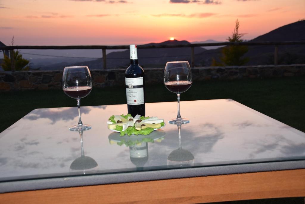 爱尔巴桑Sofra E Shpatit的一张桌子,上面放有两杯酒和一瓶葡萄酒