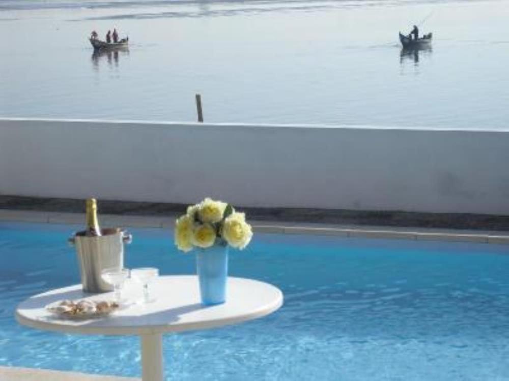 诺瓦海岸Casa do Bico da Biaritz的一张桌子,上面有花瓶,旁边是游泳池