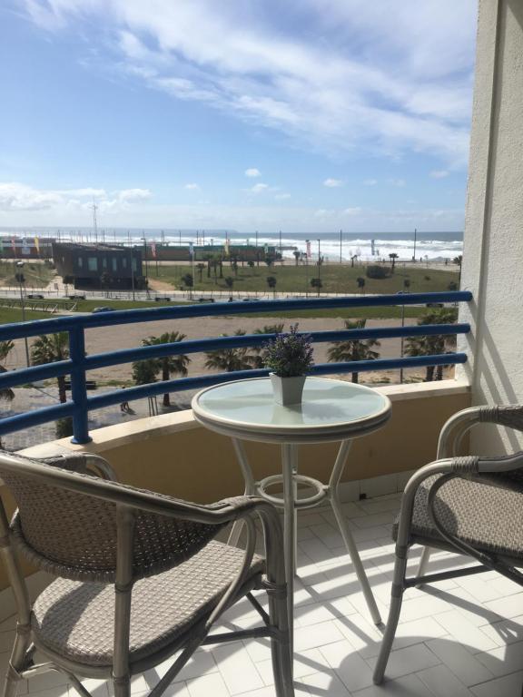 卡帕里卡海岸Paradise的海滩景阳台配有桌椅