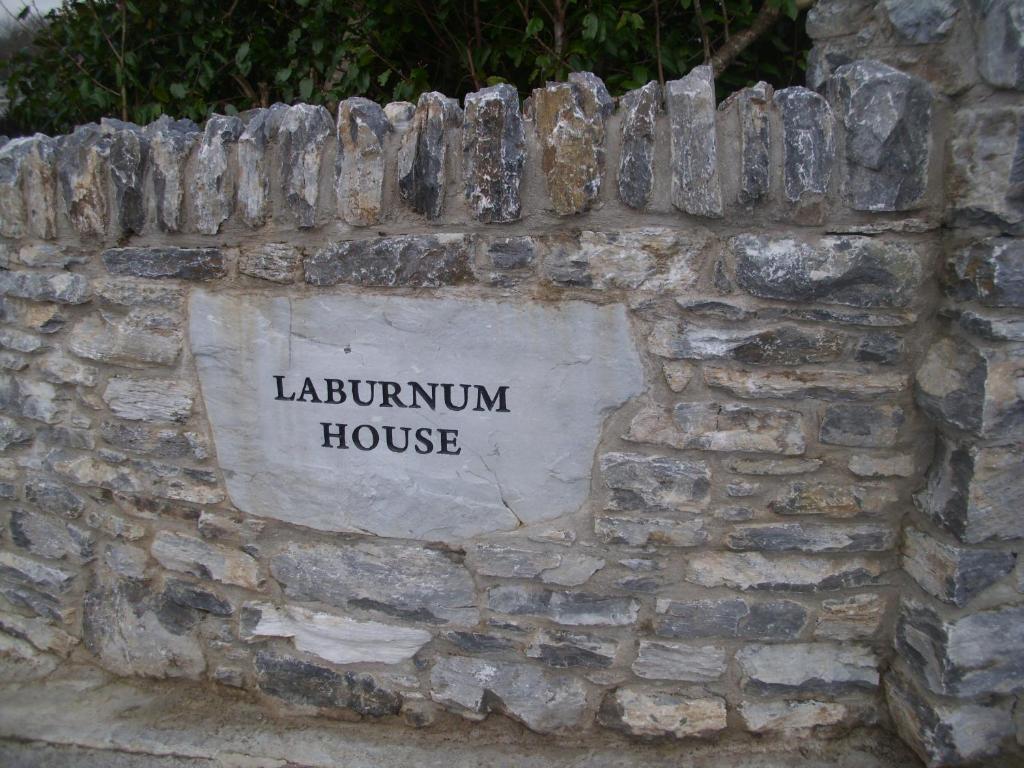 肯梅尔Laburnum B&B的石墙,上面有读书包房子的标志