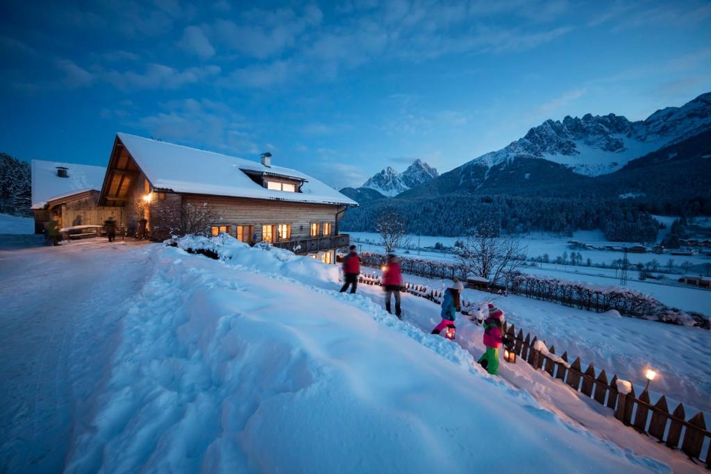 圣坎迪朵Im Kranzhof的一群人站在谷仓前的雪中