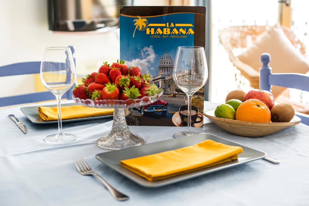 罗列特海岸La Habana Apart Hotel的一张桌子,上面放有一盘水果和酒杯