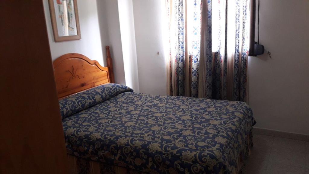 马拉加Nuevo Montesol的一间卧室配有床和带窗帘的窗户