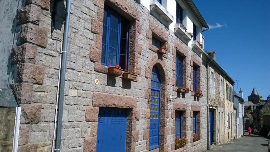特雷吉耶Chambres de Scavet的街道上设有蓝色门窗的建筑