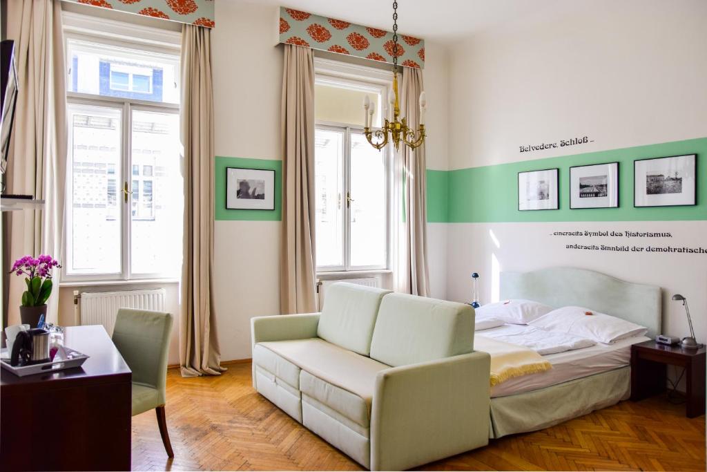 维也纳雷德尔旅馆的一间卧室配有一张床、一张沙发和一把椅子