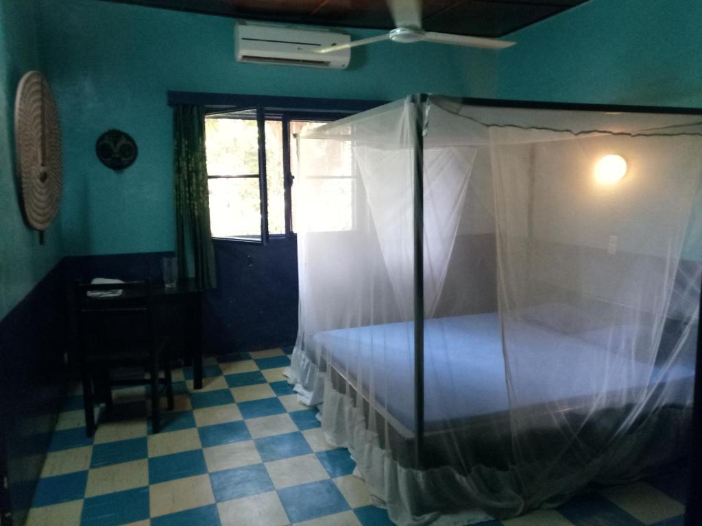 博博迪乌拉Villa Bobo的一间卧室配有一张带蚊帐的床