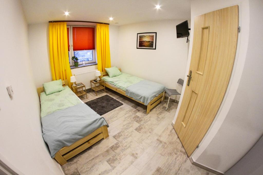 亨齐内Na Krzywej的小房间设有两张床和窗户
