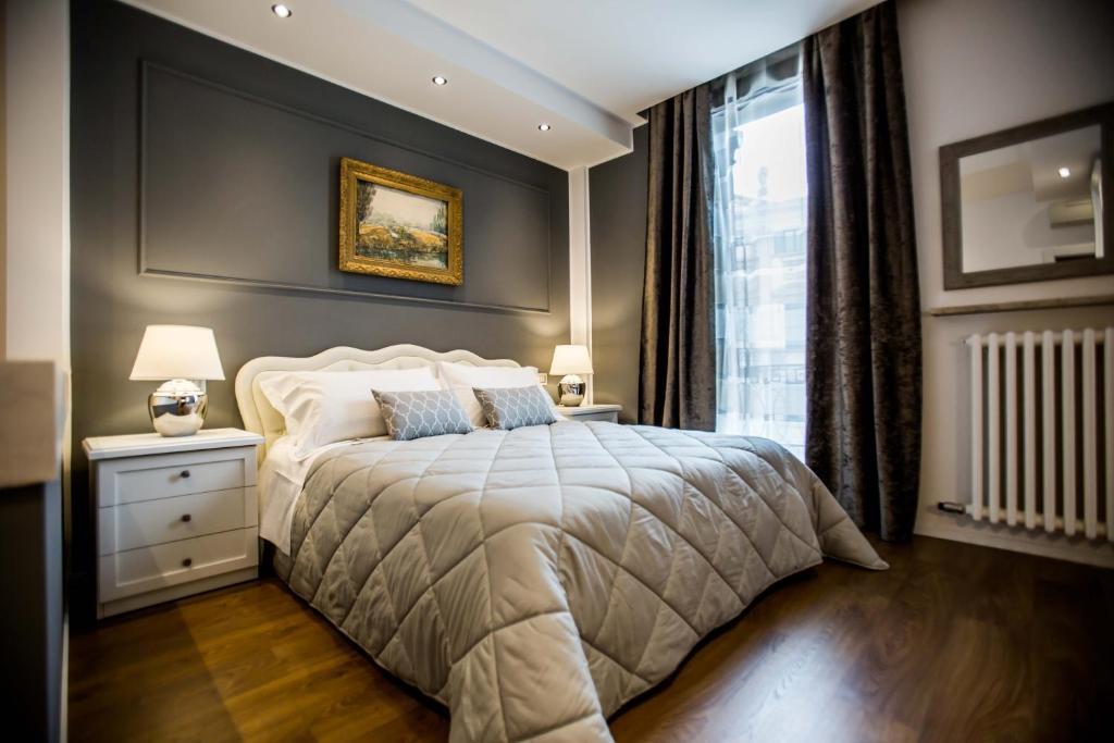 维罗纳竞技场套房酒店的一间卧室设有一张大床和一个窗户。