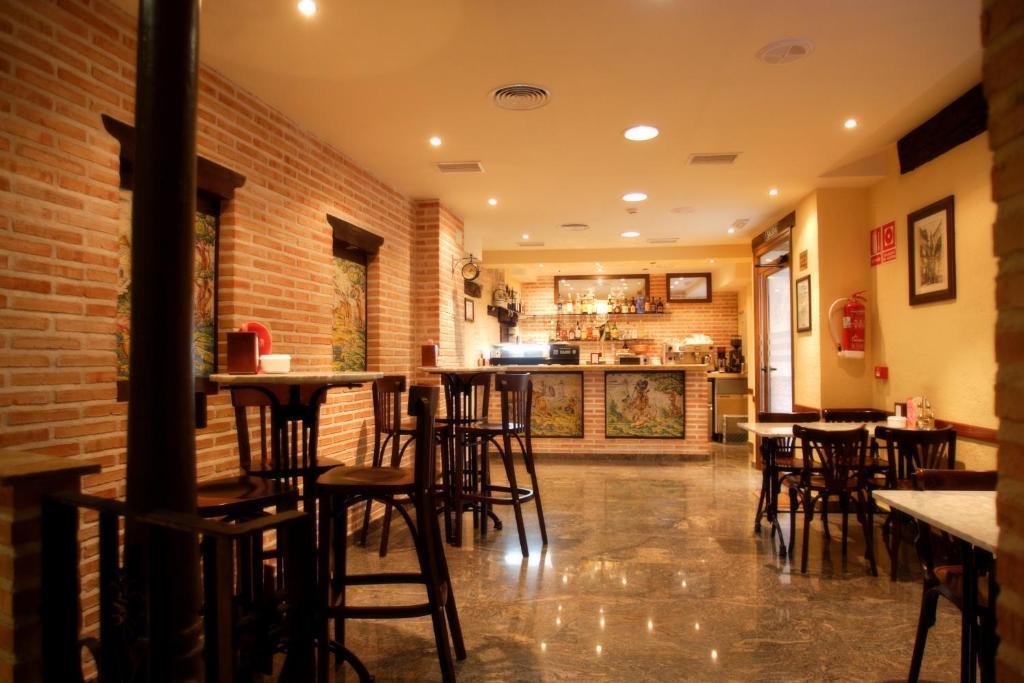 托莱多尤里科酒店的餐厅内的酒吧,配有桌椅