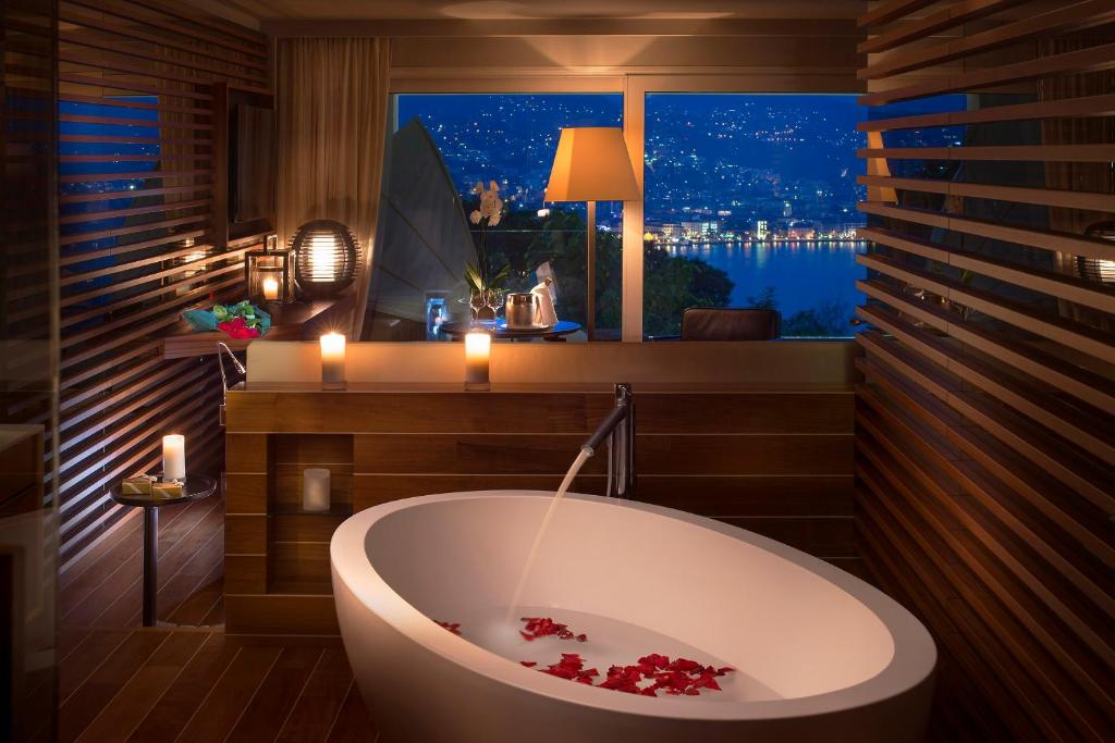卢加诺卢加诺风景酒店的带浴缸的浴室和窗户