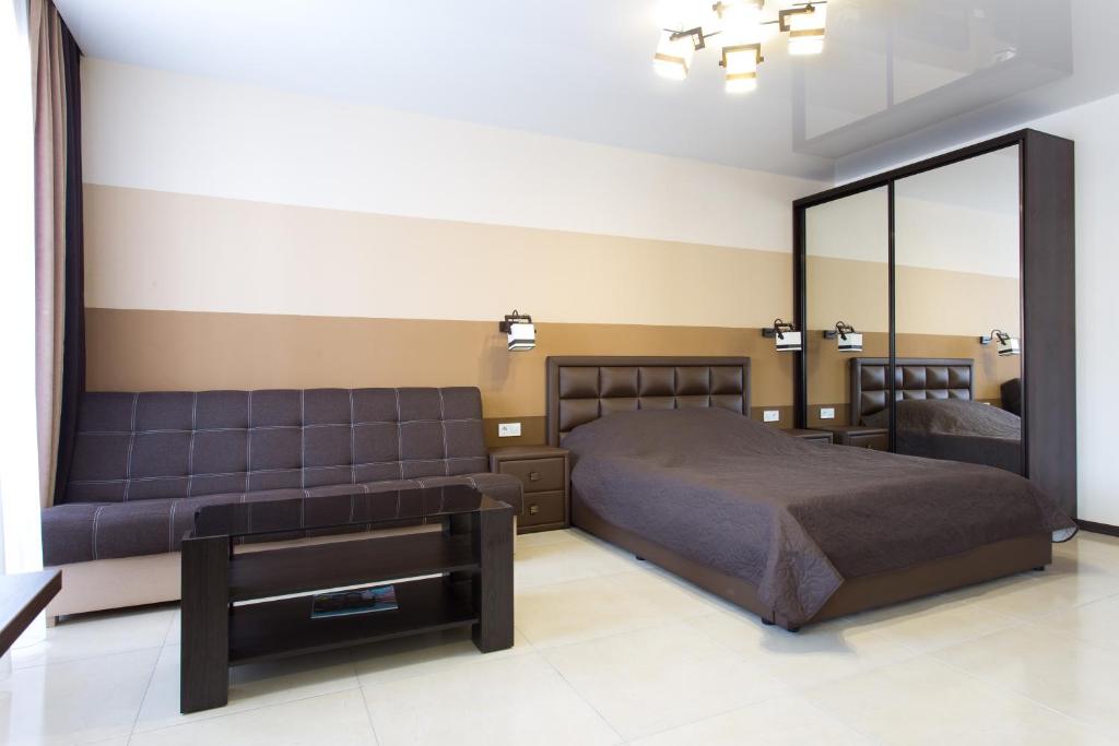 哈尔科夫Luxury Studios on Nauki Avenue的一间卧室配有一张床和一面大镜子