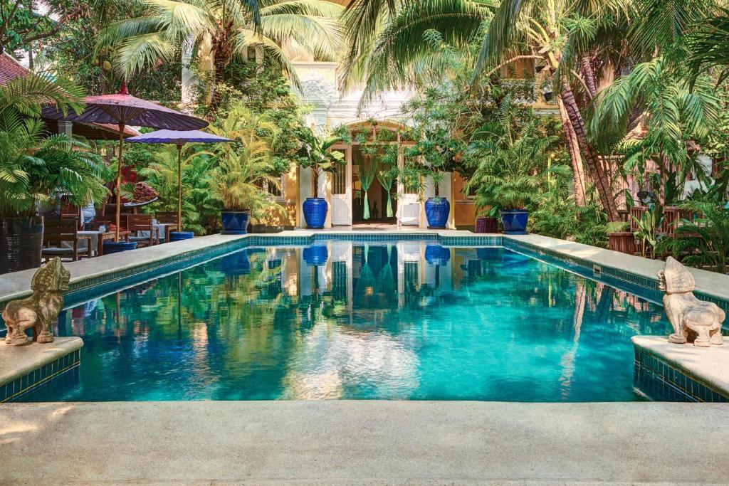 金边PAVILION的一座拥有蓝色海水和棕榈树的游泳池