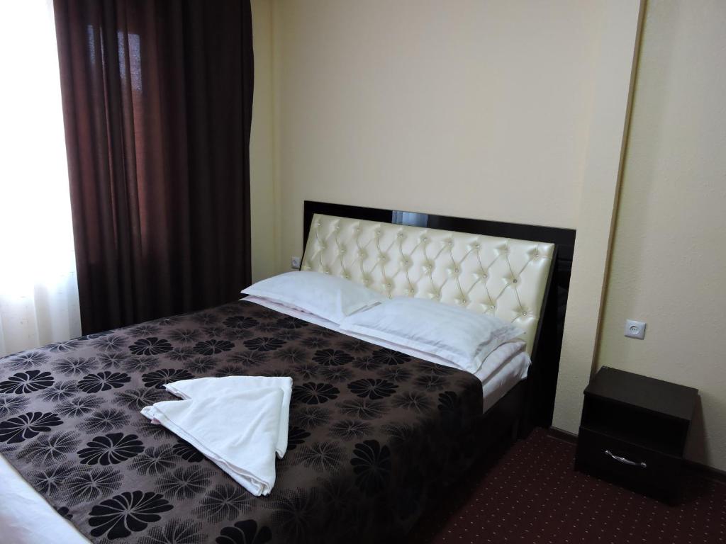 乔尔蓬阿塔Inn Kochevnik的一间卧室配有一张带两条白色毛巾的床