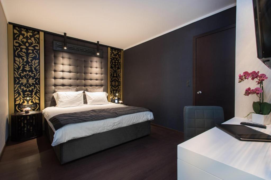 塞萨洛尼基Egnatia Palace Hotel & Spa的一间卧室配有一张大床和大床头板