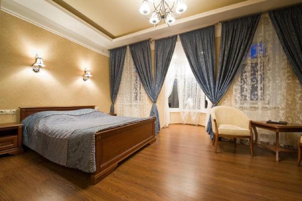 卡卢加德沃雅恩斯卡娅酒店的卧室配有床、椅子和窗户。